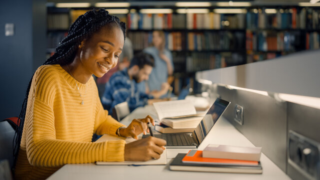 Student working on a laptop in a quiet library study area